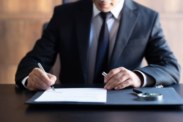 businessman signing contract in the office - condition text magnifying glass contract imagens e fotografias de stock