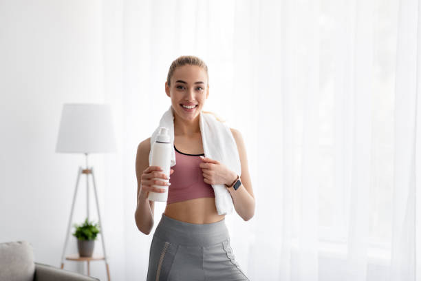 istock Woman drinking water at home, taking break after exercise 1331293512