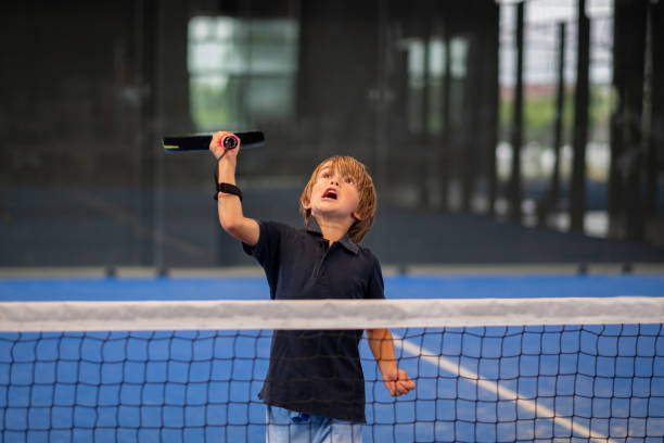 monitor teaching padel class to man, his student - trainer teaches boy how to play padel on indoor tennis court - padel stockfoto's en -beelden
