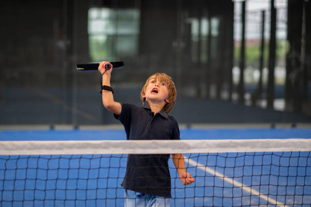 monitor nauczania padel klasy do człowieka, jego uczeń - trener uczy chłopca, jak grać padel na krytym korcie tenisowym - indoor tennis zdjęcia i obrazy z banku zdjęć