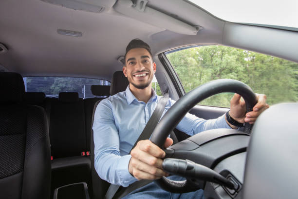istock Smiling arab guy driving his car, shot from dashboard 1331293750