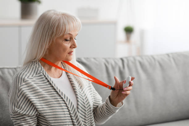 istock Senior woman holding and using Alarm Button, closeup 1331293840