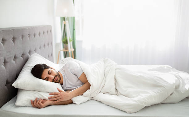 istock Bedtime. Tired millennial arab man asleep, resting peacefully in white comfortable bed in bedroom, copy space 1331294576
