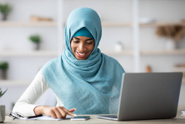 istock Remote Entrepreneurship. Black Islamic Businesslady Using Smartphone While Working At Home Office 1331295230