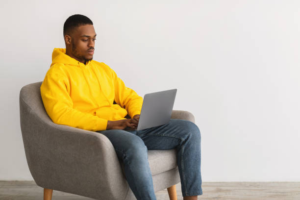 istock African Freelancer Guy Using Laptop Working Online, Gray Background, Side-View 1331295282