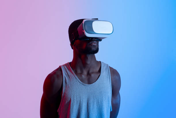 istock Fit black guy wearing VR headset, exercising with virtual reality gear in neon lighting 1331295423