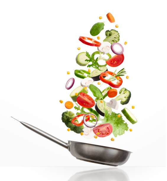 istock Fresh vegetables flying into a pan, isolated on white background 1331296200