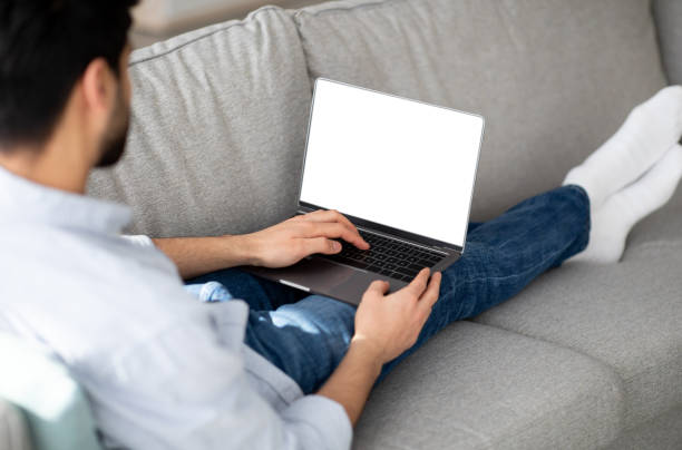 istock Advertisement concept. Millennial man using modern laptop with empty screen at home, mockup for your website or design 1331296622