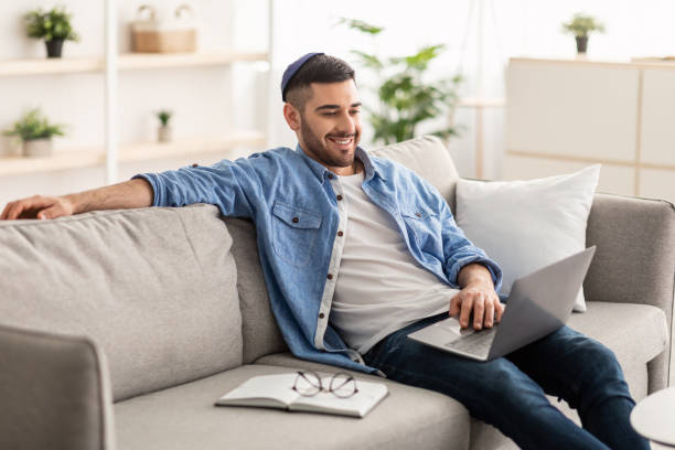 istock Smiling jewish man watching video on computer 1331296761