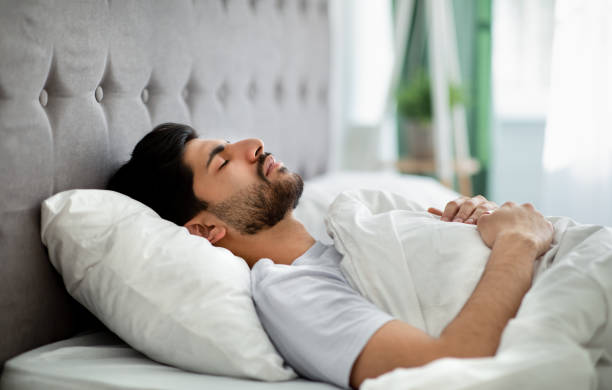 istock Deep male sleep. Young arab guy sleeping peacefully in his comfortable bed at home, lying with closed eyes on back 1331296837