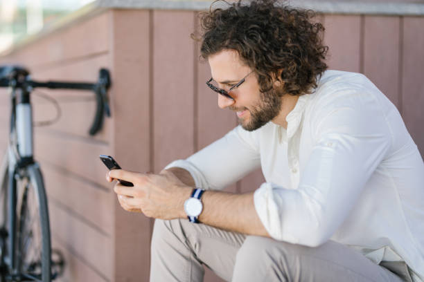 istock Fashionable and good looking young businessman using his phone while taking a break from cycling 1331297770
