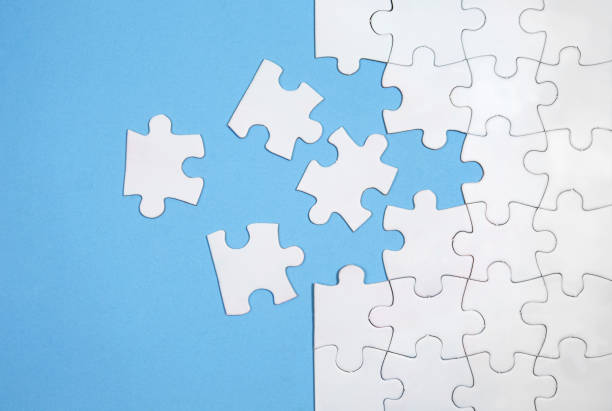 istock Unfinished white jigsaw puzzle pieces on blue background 1331298330