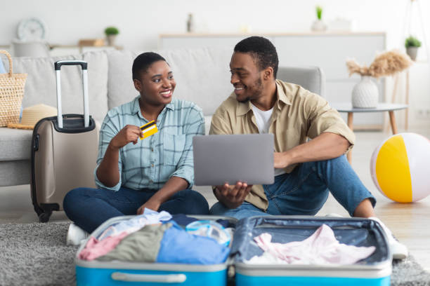 istock Black Couple Using Laptop And Credit Card Booking Vacation Indoor 1331299325