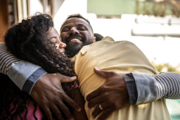 Father embracing son and daughter at home