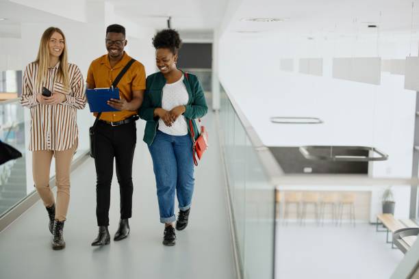 istock Multiethnic student friends walking in college campus 1331300108