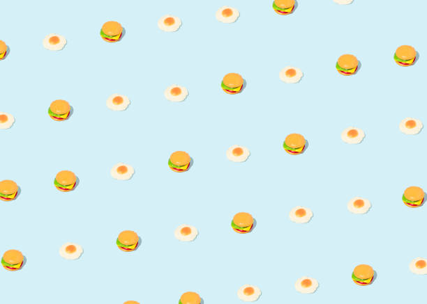 istock Minimal food pattern made with a burger and fried egg candies on bright blue background. Creative fast food concept. 1331300242