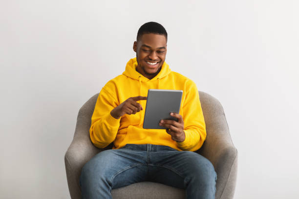 istock African American Male Using Digital Tablet Sitting Over Gray Background 1331303939