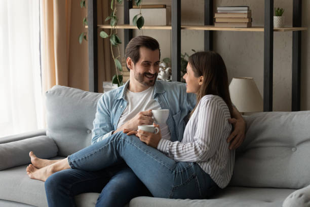 istock Loving spouses relax on sofa with cups of tea 1331304098