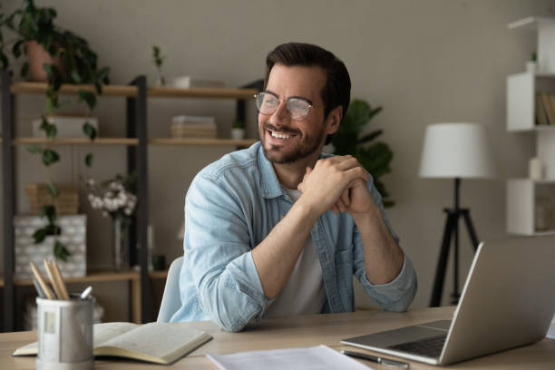 istock Smiling successful entrepreneur sit at desk looking into distance 1331304127
