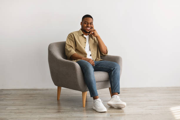 istock Successful African American Man Posing Sitting In Chair, Gray Background 1331304457