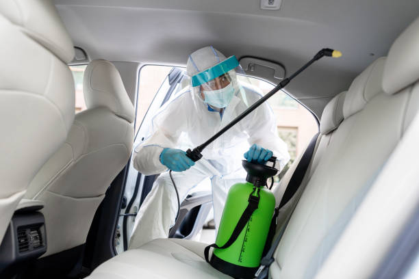 istock Specialist cleaner wearing personal protective equipment PPE using chemical alcohol spray 1331305087