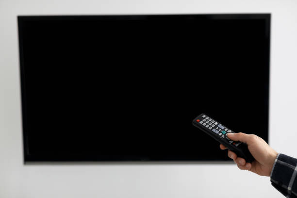 istock Blank TV Screen And Hand With Television Remote Control Indoor 1331305868