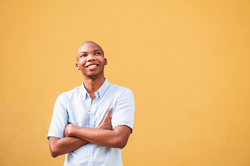 Portrait of cheerful African American man pensively looking up. copy space concept.