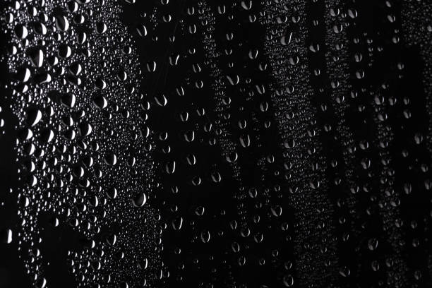 istock Water droplets on black acrylic background. Rain drops perched on glass on a black background 1331306785