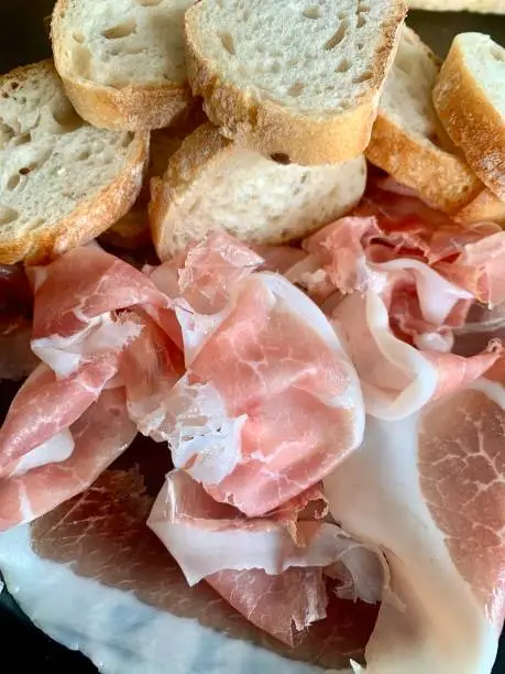 Wafer-thin sliced raw ham with baguette