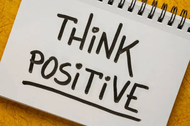 Think positive inspirational handwriting in a sketchbook, positivity, optimism and mindset concept
