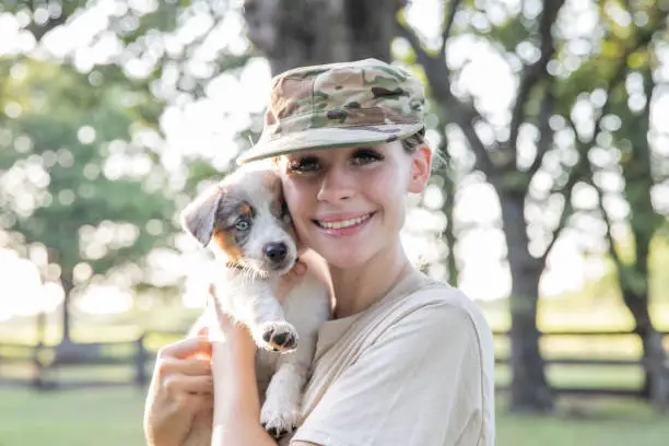 Photo of Young soldier smiles while holding a new puppy