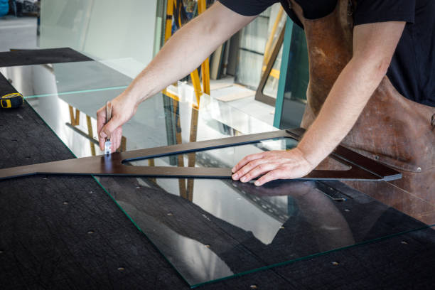 istock Glass workshop, Glazier cuts transparent glass with a specialist knife and angle 1331323794