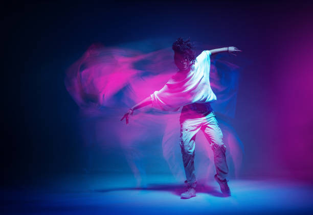 istock Stylish dancing modern girl moving in colorful neon studio light. Long exposure. Copy space 1331324401