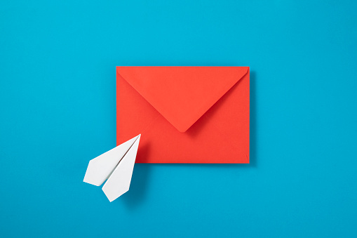 E-mail concept with paper plane and red envelope on blue background