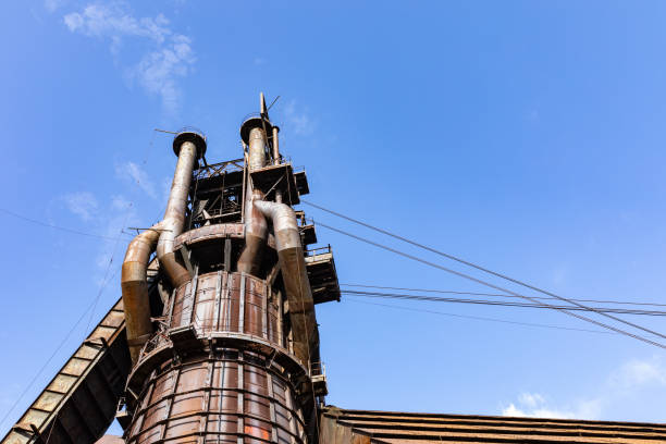 istock Large industrial structure in an abandoned steel mill complex, rusting metal contrasting against a bright blue sky 1331330739