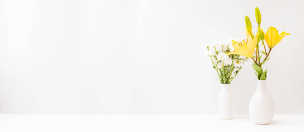 istock Home interior with decor elements. Yellow lilies in a vase on a light background 1331335167