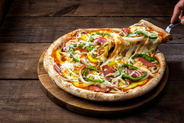 Pizza with yellow and green bell pepper and pepperoni.