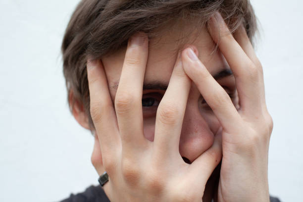 istock Young man in depression covers his face with his hands 1331342544