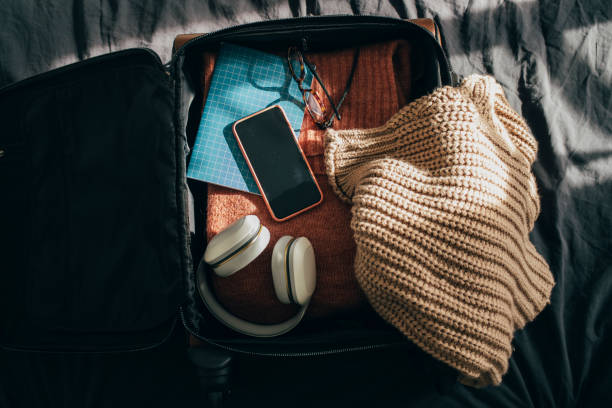 Open Luggage with Clothes and Other Object on Bed at Home Packing up suitcase for vacation and preparing for a journey, flat lay winter still life stock pictures, royalty-free photos & images