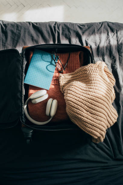 istock Open Luggage with Clothes and Other Object on Bed at Home 1331344829