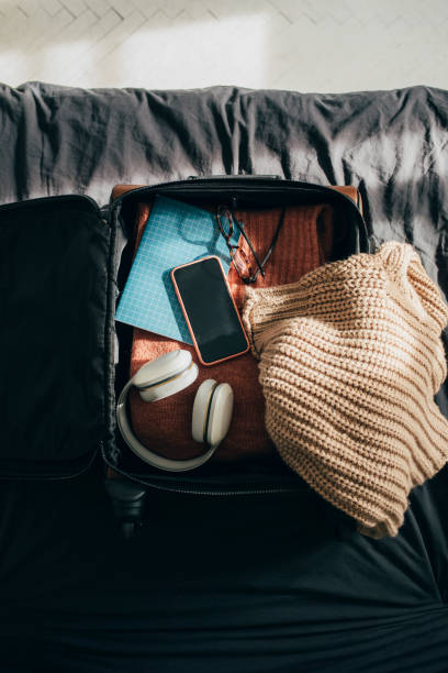 istock Open Luggage with Clothes and Other Object on Bed at Home 1331344837