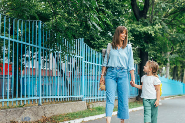 istock Smiling Mother Taking her Daughter to School 1331345411