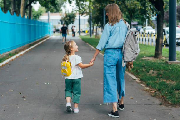 Unrecognizable Mother Taking her Daughter to School stock photo