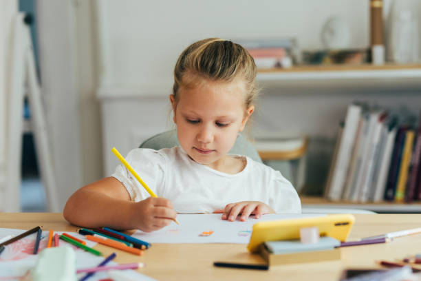 istock A Cute Girl Looking at her Smartphone and Drawing 1331345800