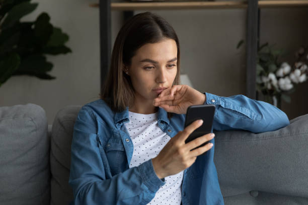 istock Serious woman sit on sofa read sms feels upset 1331346476
