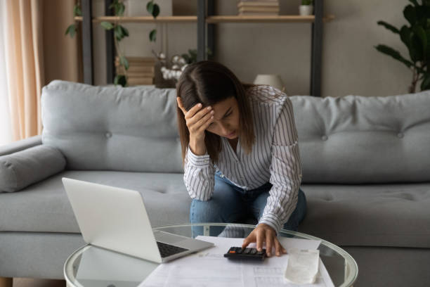 Desperate woman feeling stressed about financial problems Desperate young woman sit on sofa at home calculates expenses feeling stressed about bank loan payments, lack of money, financial problems, thinking of unpaid taxes, bankruptcy, overdue bills concept debt stock pictures, royalty-free photos & images