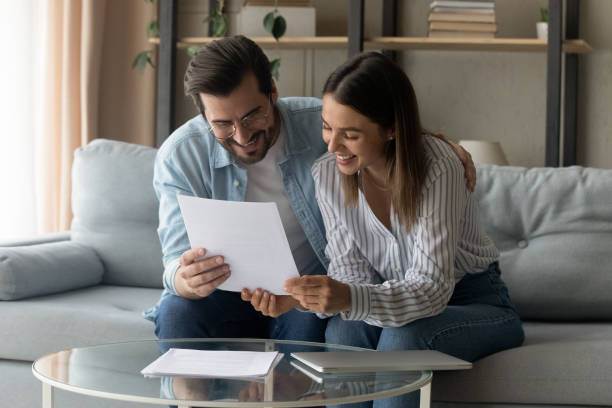 istock Smiling couple sit on sofa reading received formal letter 1331346514