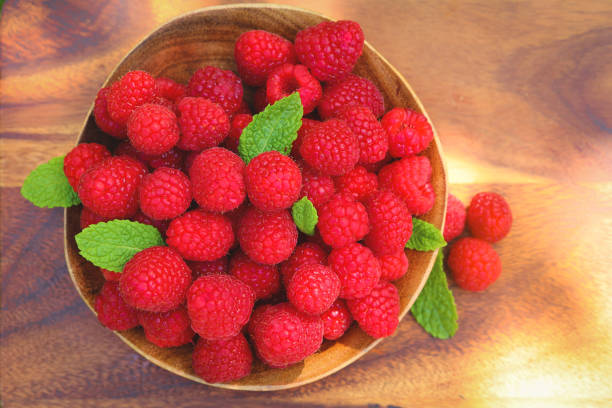 istock Ripe raspberries on wooden bowl 1331347195