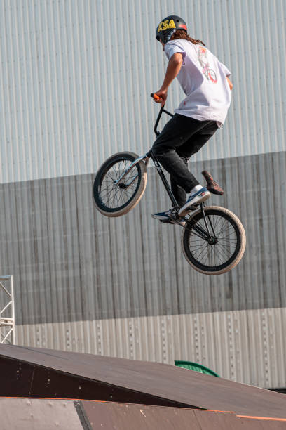 un giovane pilota su una bici bmx fa trucchi in aria - bikers point of view foto e immagini stock