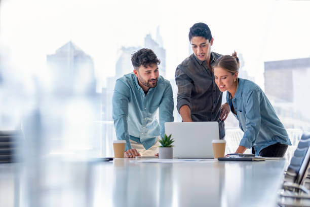 équipe d’affaires travaillant sur un ordinateur portable. - board room group of people business person clothing photos et images de collection